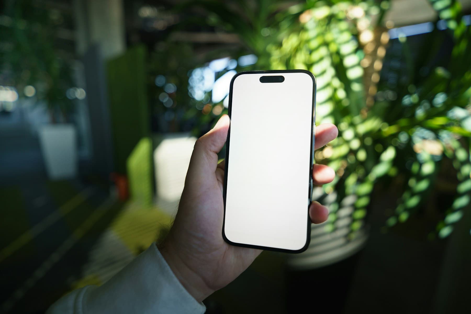 Phone mockup held in hand with a blank screen