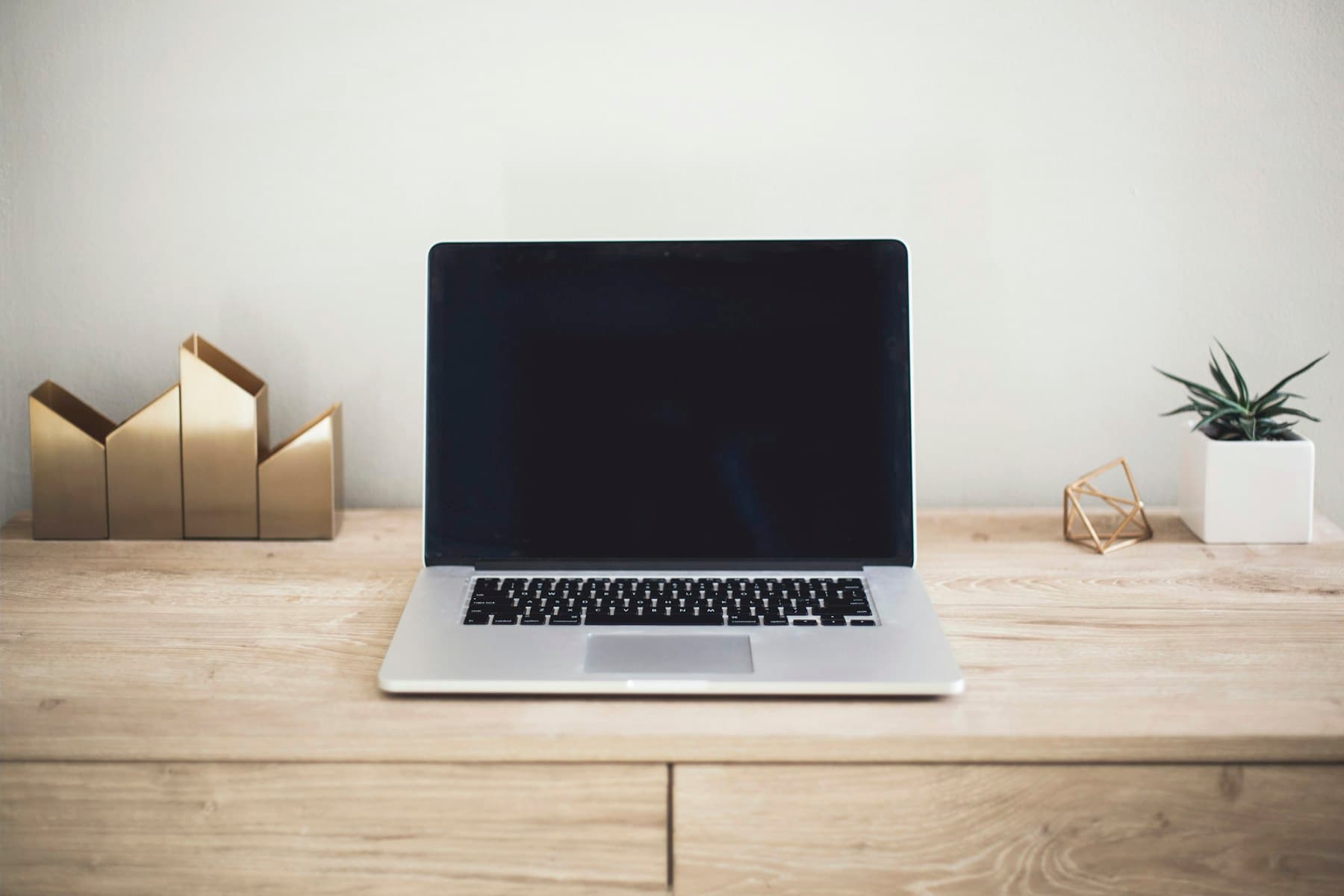 MacBook mockup on a minimal white table